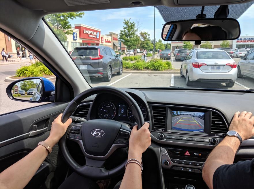 Student successfully completing a reverse parking maneuver under the supervision of a driving instructor